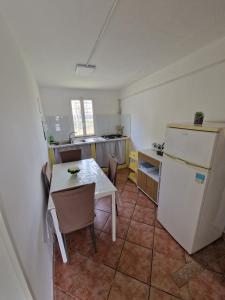 a small kitchen with a table and a refrigerator at Casa Alba Paestum in Paestum