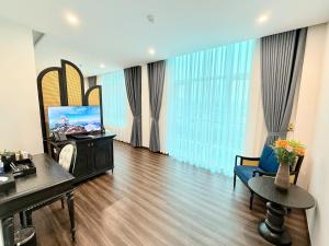 a living room with a television and a couch and a table at Kana Boutique Hotel Ninh Bình in Ða Gia