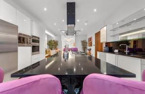 a kitchen with pink chairs and a large long table at 250 SqM MEGA MANSION in London