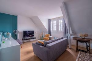a living room with a couch and a tv at L'HIRONDELLE in Mosnes