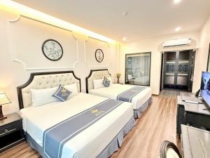 a hotel room with two beds and a television at Kana Boutique Hotel Ninh Bình in Ða Gia +45 photos