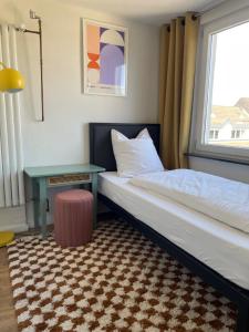 科隆Weltempfänger Backpacker Hostel的一间卧室，里面有一张床、一张桌子和一扇窗户