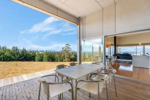 a dining room with a table and chairs at Marion Bay House, Luxury Retreat in Bream Creek