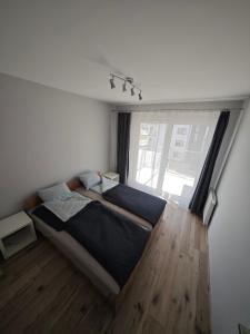a bedroom with a large bed and a large window at apartament MAKI in Nowy Targ