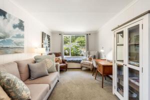 un soggiorno con divano e scrivania di Secluded Huon Valley Lodge with Hot Tub and Cottage a Lymington
