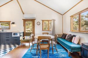 un soggiorno con un tavolo e un divano di Secluded Huon Valley Lodge with Hot Tub and Cottage a Lymington