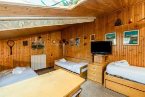 Una habitación con dos camas y un televisor de pantalla plana. en Tonale Sky Attic - Ponte di Legno by InnStay, en Ponte di Legno