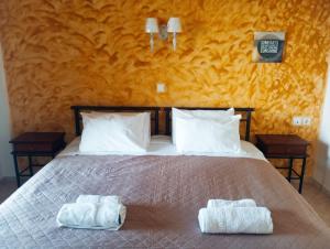 a bedroom with a bed with two towels on it at Iridis R & R in Ligaria