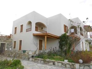 a large white house with balconies on the side of it at Iridis R & R in Ligaria