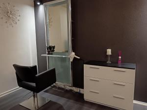 a bathroom with a mirror and a chair and a dresser at Salon Harlekiini in Lieksa