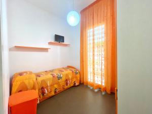 Una pequeña habitación con una cama y una ventana. en Villa Dolce Rumore, en Bari