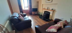 a living room with two couches and a fireplace at Tigh an Data, Borrisdale, South Harris in Rodel +9 photos