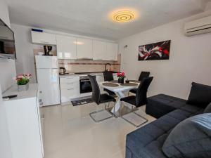 a kitchen and a living room with a table and chairs at Apartments MajaPaula in Slatine