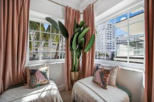 a room with two beds and a window with a plant at Le Particulier Miami in Miami Beach