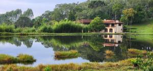 a house sitting on the side of a lake at Hospedaria Soraya Alegre in Campina Grande do Sul +10 photos