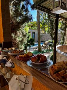 a buffet with bread and pastries on a table at Pousada Na Natureza in São Bento do Sapucaí