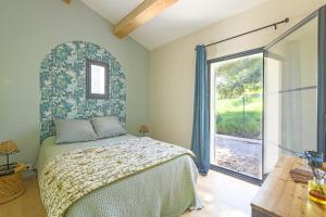 a bedroom with a bed and a large window at Le Montebello de Paradou in Paradou