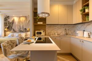 eine Küche mit weißen Schränken und ein Bett in einem Zimmer in der Unterkunft Mery Suite in Verona