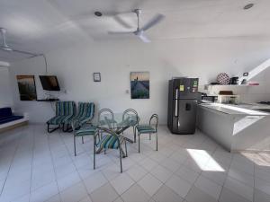 a kitchen with chairs and a table and a refrigerator at Descansa en familia en Rio Bonito lleva tus mascotas in Melgar