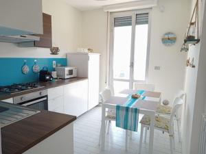 a kitchen with a table with chairs and a microwave at L'Attico sul Porto, Sea View with Terrace, Imperia Center in Imperia