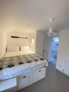 ein weißes Schlafzimmer mit einem Bett und einer Decke in der Unterkunft Charming, stylish cottage, parking , large private Garden, well located for island highlights in Gaerwen