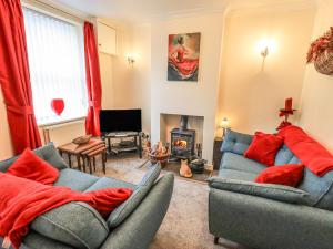 a living room with two couches and a fireplace at Violey Cottage in Maryport