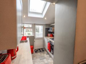 a small kitchen with a skylight in the ceiling at Violey Cottage in Maryport