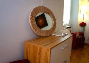 a mirror on top of a dresser in a room at PortaTorre Suite, a Charming apartment in the Heart of Como, Free Private Parking, Air Conditioning & More! in Como