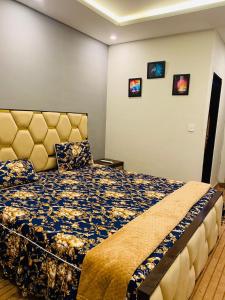 a bedroom with a bed with a blue and yellow bedspread at Haris villa in Dargai