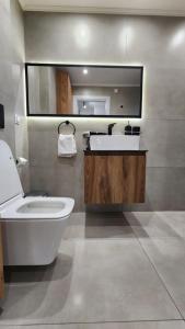 a bathroom with a sink and a toilet and a mirror at Four Suns Loft in Thessaloniki +7 photos