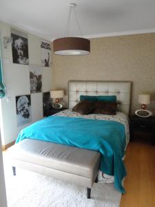 1 dormitorio con 1 cama grande con manta azul en Apartamento Raio de Sol, en Caniço