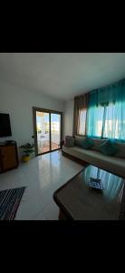 a living room with a couch and a table at plage al amine eden in Fnidek