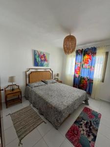 a bedroom with a bed and two windows with curtains at plage al amine eden in Fnidek
