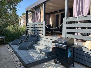 a grill sitting on the front porch of a house at Danyja Mobilehome in Biograd na Moru