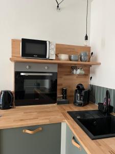 a kitchen with a microwave on top of a counter at Duplex Centre Ville Lannion in Lannion +10 photos
