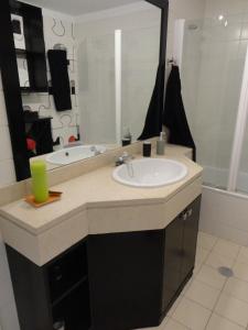 a bathroom with a sink and a mirror and a tub at Apartamento Raio de Sol in Caniço