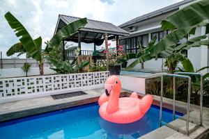 an inflatable flamingo is sitting in a swimming pool at Villa RNB 2BR Medan in Sunggal