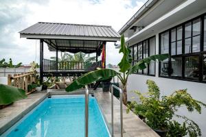 a house with a swimming pool and a balcony at Villa RNB 2BR Medan in Sunggal