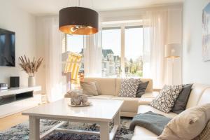 a living room with a couch and a table at Ferienwohnung Ostseekoje - Haffkrug in Haffkrug
