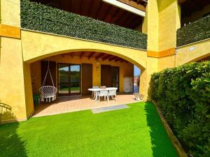 een terras met een tafel en groen gras bij Casa Luisa in Desenzano del Garda