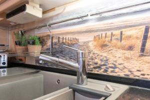 a kitchen with a window with a view of a beach at Ferienwohnung Ostseekoje - Haffkrug in Haffkrug +36 photos