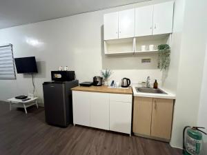 a small kitchen with a sink and a refrigerator at Amaia step parkway nuvali studio in Calamba