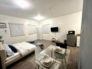 a living room with a bed and a table at Amaia step parkway nuvali studio in Calamba
