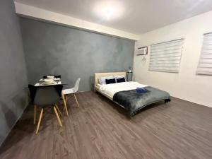 a bedroom with a bed and a desk and a chair at Amaia step parkway nuvali studio in Calamba