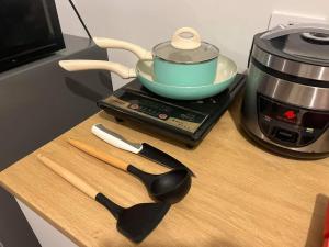 a counter with a pot and a bowl on top of a coffee maker at Amaia step parkway nuvali studio in Calamba