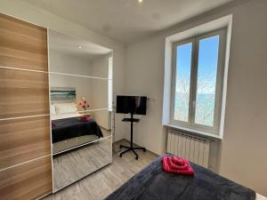 a bedroom with a mirror and a bed and a television at Splendida Casa vista mare per 4 persone di fronte alle spiagge di Bussana in Bussana Nuova