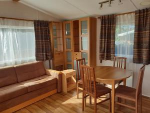 a living room with a couch and a table at Camping Pré Vologne in Granges-sur-Vologne
