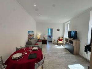 a living room with a table with a red table cloth at Splendida Casa vista mare per 4 persone di fronte alle spiagge di Bussana in Bussana Nuova