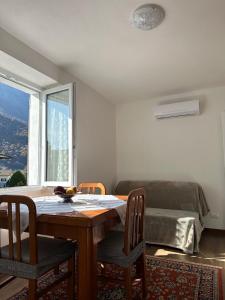 a dining room with a table and chairs and a bed at Casa Verde Valsassina 2 in Primaluna