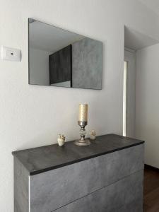 a dresser with a lamp and a mirror on the wall at Casa Verde Valsassina 2 in Primaluna +22 photos